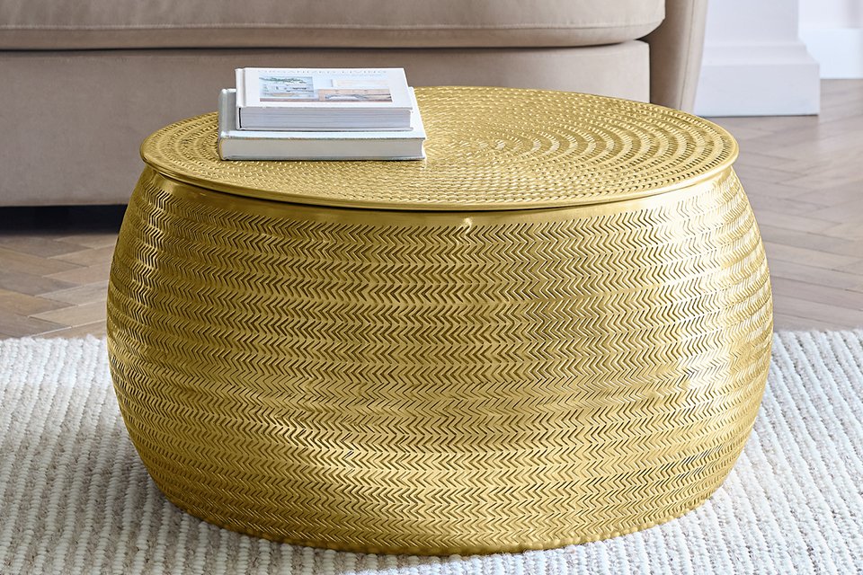 Books on a Habitat Sona brass coffee table with storage.