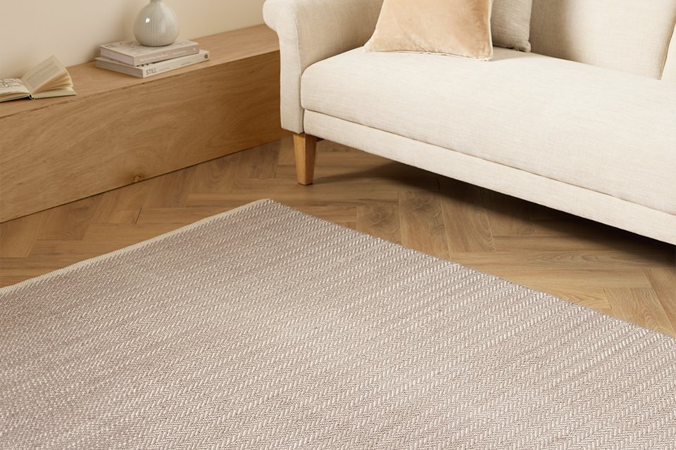 An Argos Home herringbone grey cotton flatweave rug in a living room.