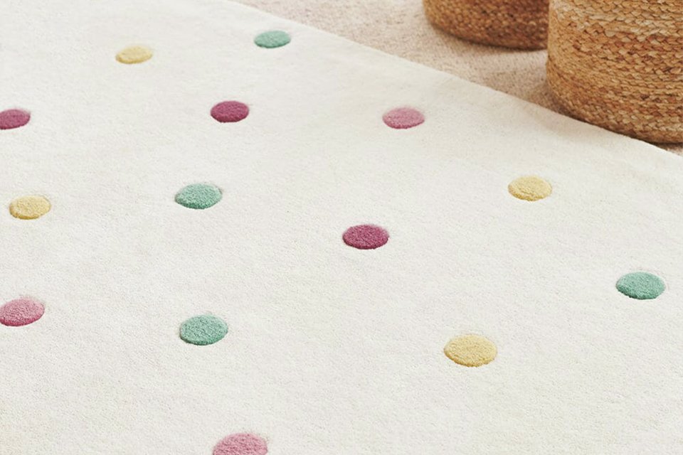 A Great Little Trading Company pastel spot natural wool cut pile rug in a kids' room.