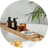 A Habitat bamboo bath bridge with essentials placed over a bathtub.