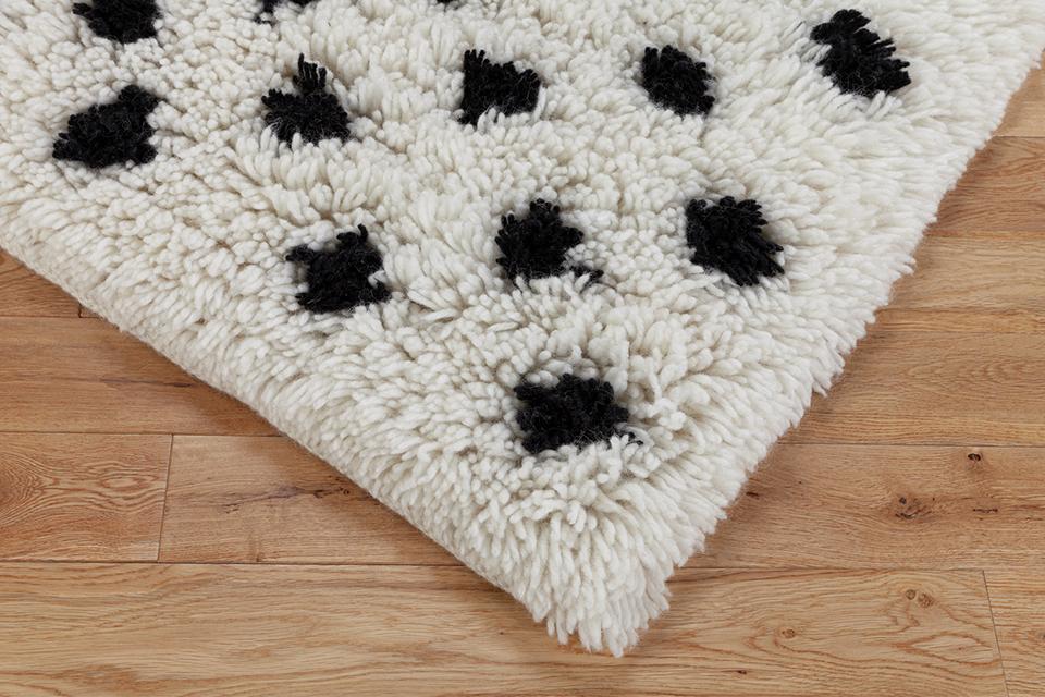 A close up corner shot of a patterned long pile rug.
