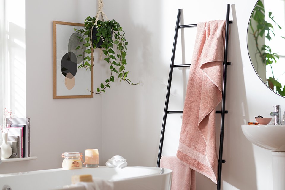 Pink bath towels hanging on bath rail.