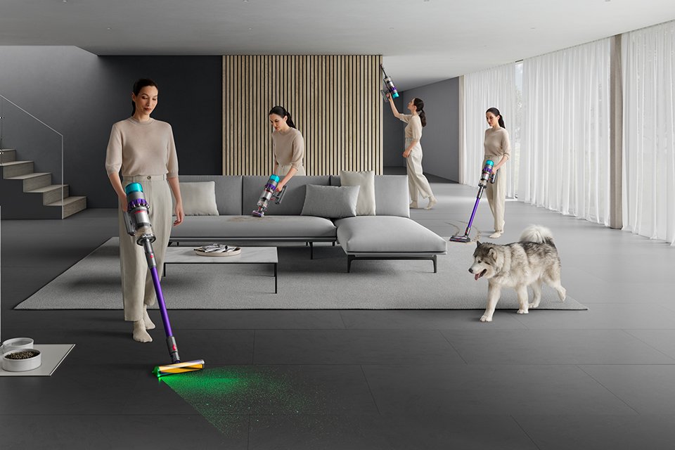 A woman showing different functionalities of the pet-friendly Dyson Gen 5 detect cordless vacuum cleaner, with laser function.