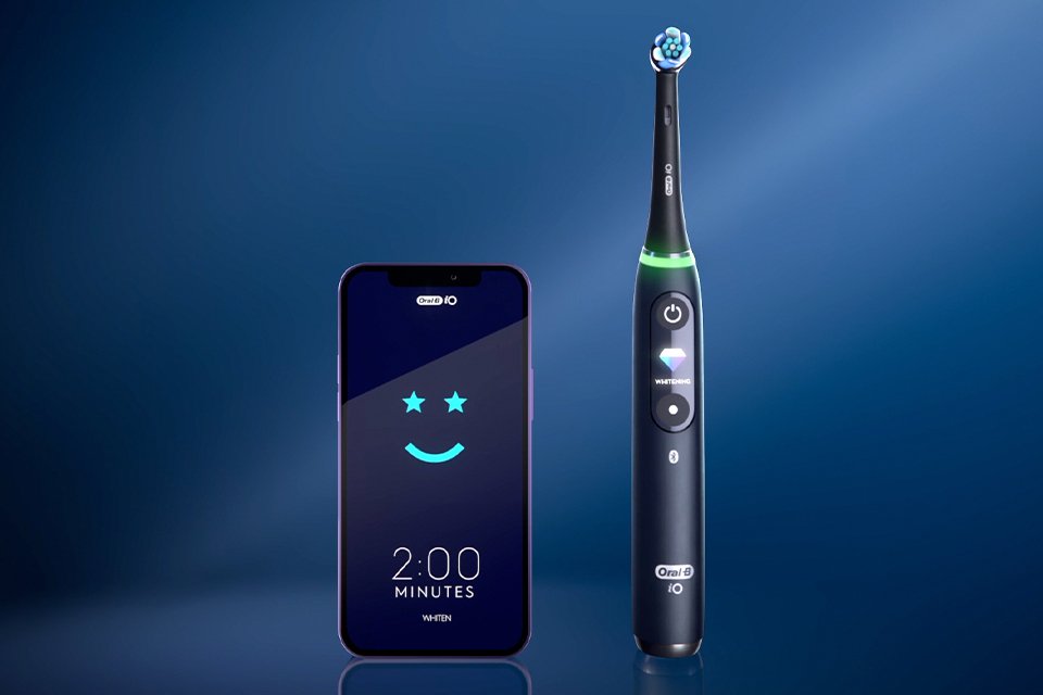 A blue Oral-B electric toothbrush next to a smartphone.