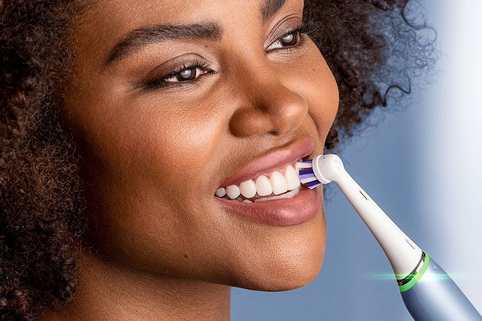 A woman brushing her teeth with Oral-B electric toothbrush.