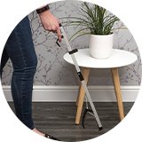 A woman using an Aidapt reacher.