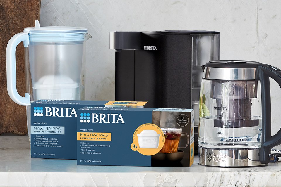 BRITA MAXTRA PRO All-In-1 and Limescale Expert water filter cartridges next to a BRITA Glass Jug, BRITA YOURCE mini water dispenser and Russell Hobbs FIlter Kettle.