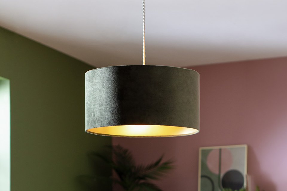 A Habitat Home green velvet lampshade in a bedroom.