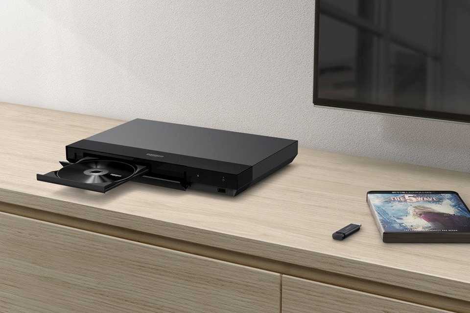 A 4K Blu-ray player with an open disc drive.