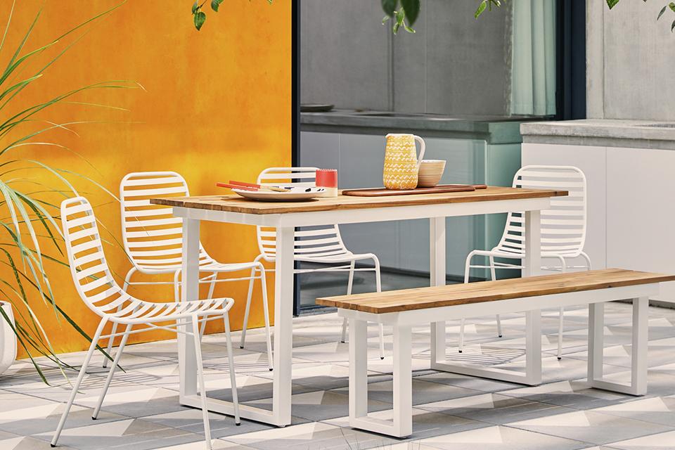 Dining set on patio with 4 white chairs and wooden bench.