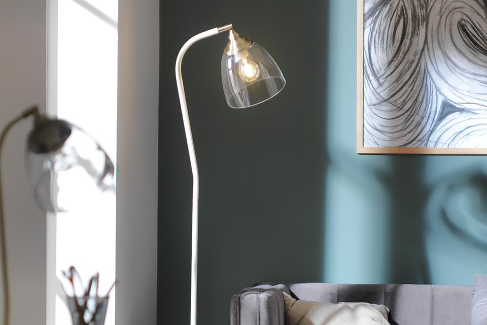 Close up of an industrial floor lamp with an exposed bulb.