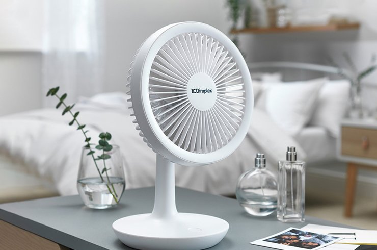 white desk fan on grey table in a bedroom
