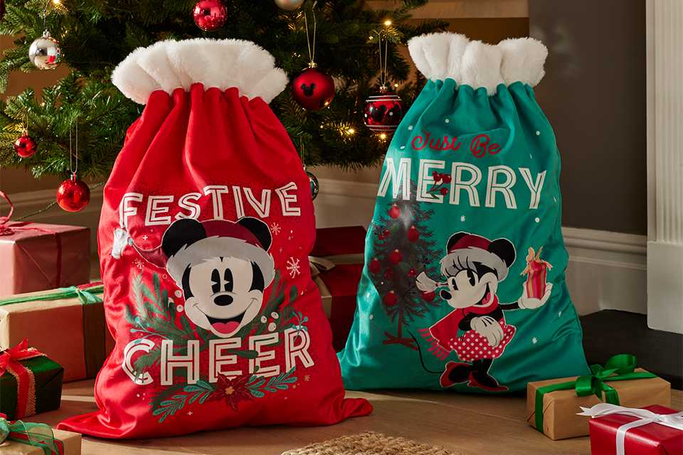 Disney Mickey and Minnie sacks under a Christmas tree decorated with Mickey baubles. 