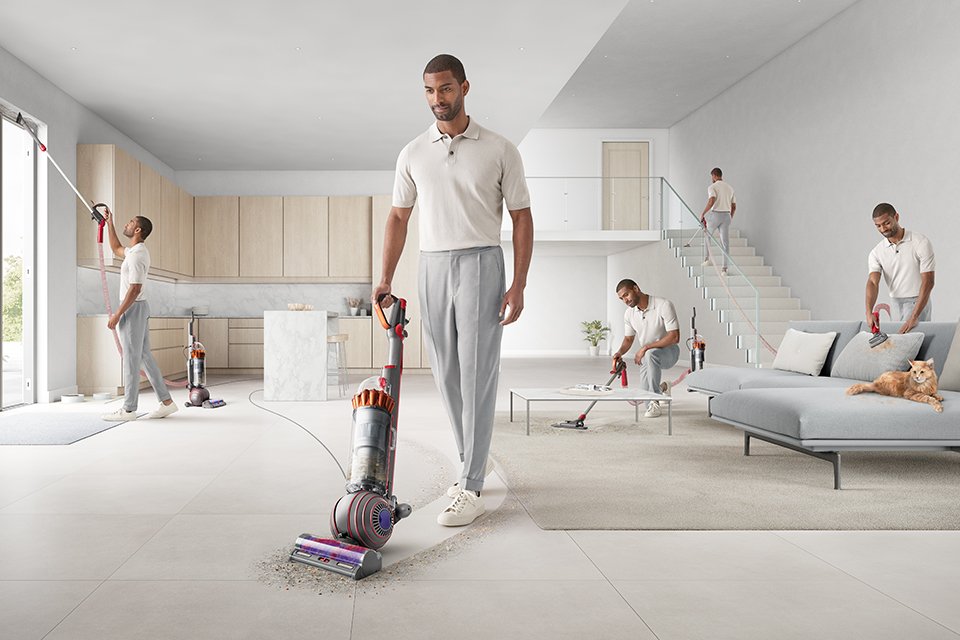 A man showing different functionalities of the Dyson ball animal multi floor vacuum cleaner with de-tangling technology, picking up pet hair.