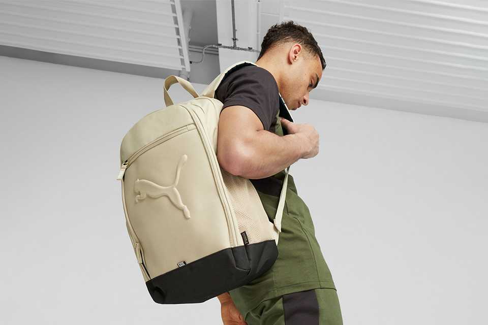 A boy carrying a Puma backpack.