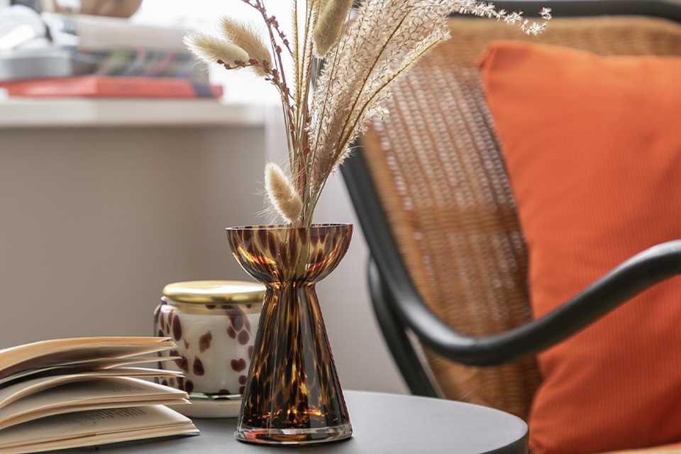 : Tortoiseshell Glass Bud Vase on side table.