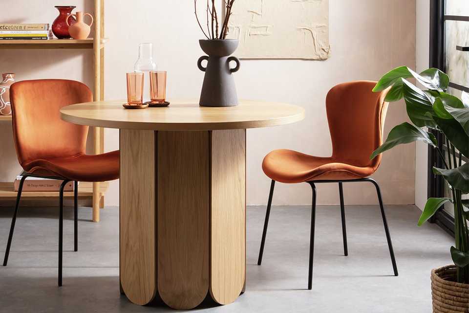 Wooden dining table in didning room with orange chairs.
