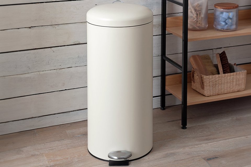Cream round pedal bin in kitchen.