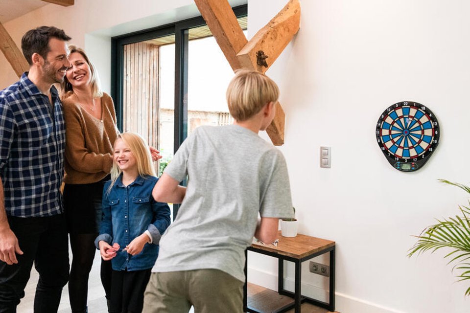 A family playing together using a Decathlon ED110 Electronic Dartboard.