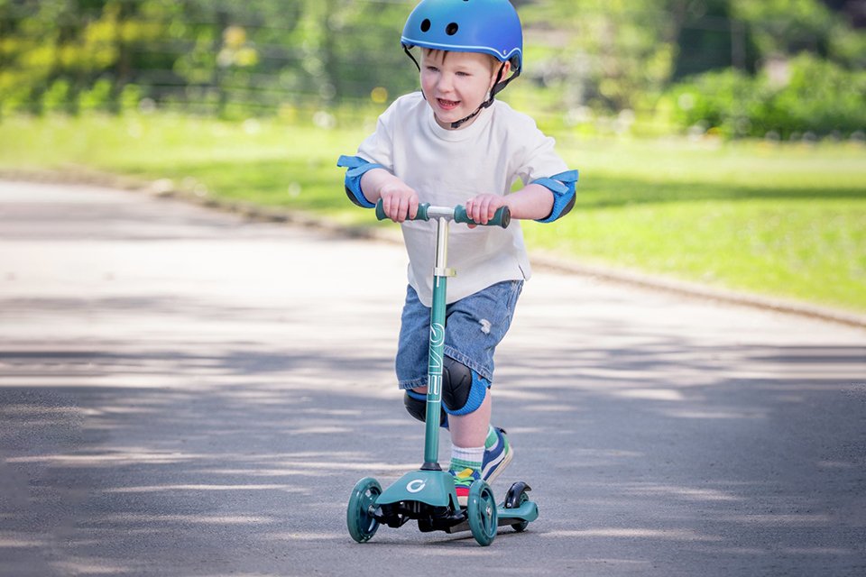 A toddler riding an Evo Mini Cruiser Tri-scooter.