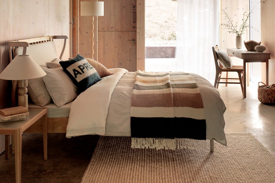 Dining room table wooden with matching benches and two boucle chairs either end.
