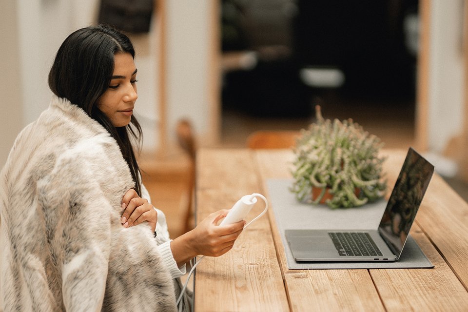 A woman using Dreamland Luxury Faux Fur Husky Heated Throw.