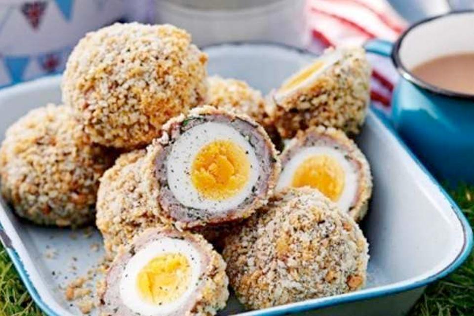 A tray filled with homemade scotch eggs; some cut in half.