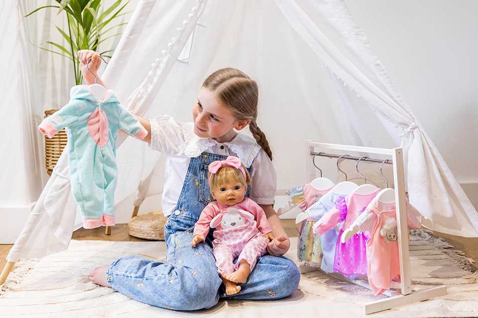 Child choosing an outfit for her 44cm Tiny Treasures baby doll.