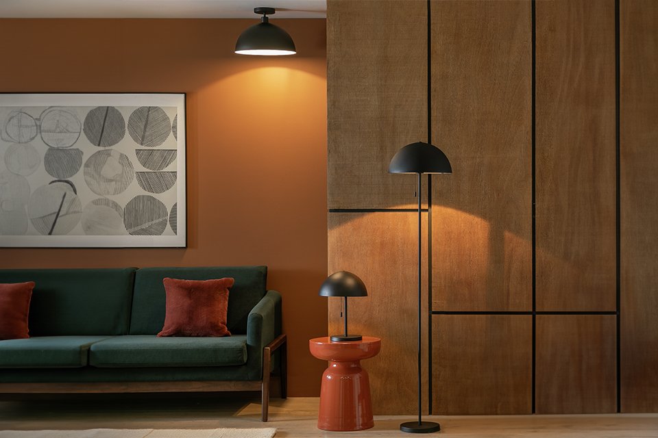 Habitat Steel Mushroom flush ceiling light, floor lamp and table lamp in black placed in a living room next to an armchair.