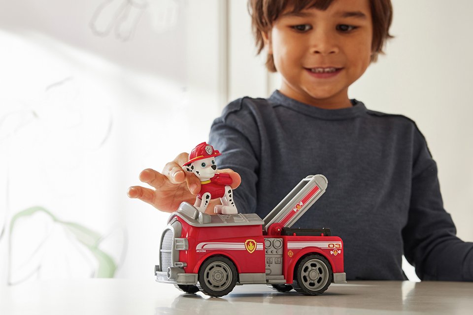 A little boy playing with PAW Patrol Marshall's fire engine.