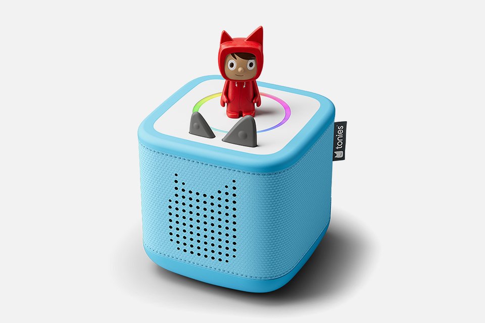 A cut out image of a blue coloured Toniebox 2 with Creative Tonie in red colour.