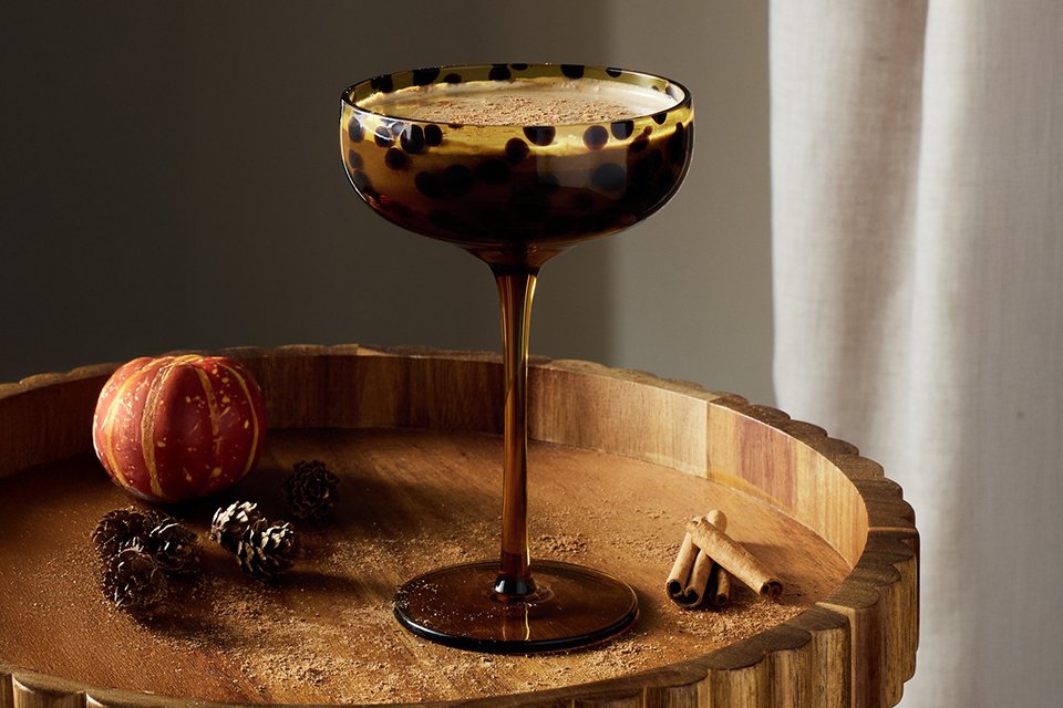 Home Confetti cocktail glass placed on a wooden tray.