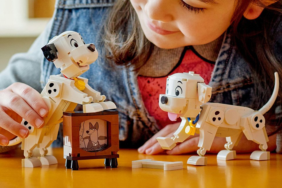 A girl playing with a LEGO Disney Lucky & Penny 101 Dalmations puppies set.