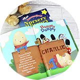 An open personalised message nursery rhyme book next to a soft toy.