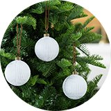 A Christmas tree decorated with Habitat glass Christmas baubles in white and silver.