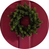 An Argos Home plain foliage Christmas wreath on a door.