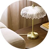 Glass flower table lamp with gold base.
