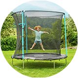 A girl jumping on a trampoline outdoors.