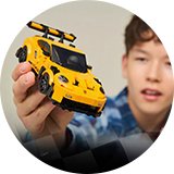 A boy playing with LEGO Speed Champions Porsche 911 GT3 RS super car toy.