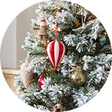 A close up image of a Christmas tree with various baubles and Christmas decorations on it.