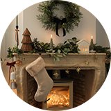 A close up image of a wreath over a mantel decorated for Christmas.