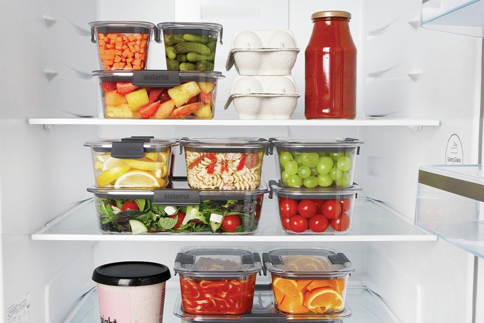 Food stored in glass storage containers and organised inside a refrigerator. 