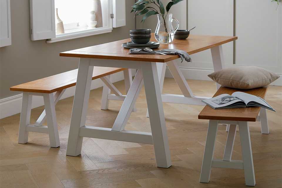 White wooden dining table with 2 benches.