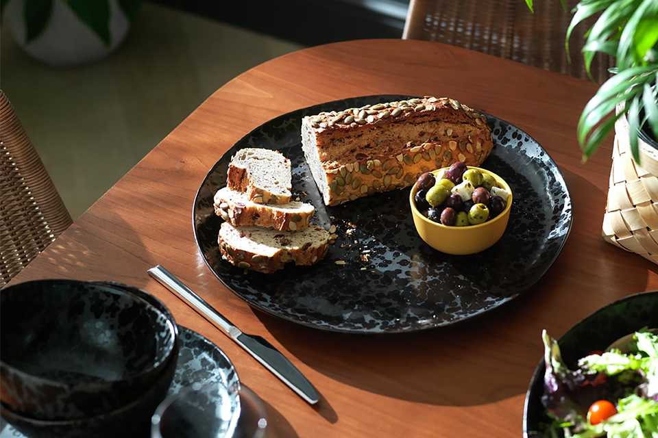 Black stoneware serving platter on a table setting.