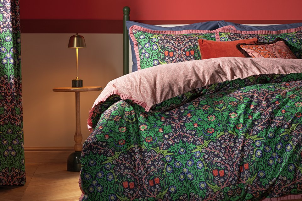 Floral green bedding with pink underside.