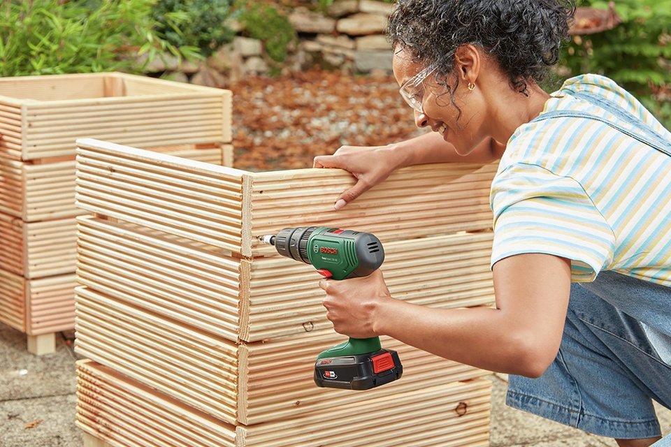 A woman using Bosch EasyImpact 18V-40 Cordless Combined Drill.