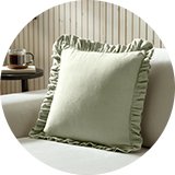 Sage green frill square cushion on accent chair .