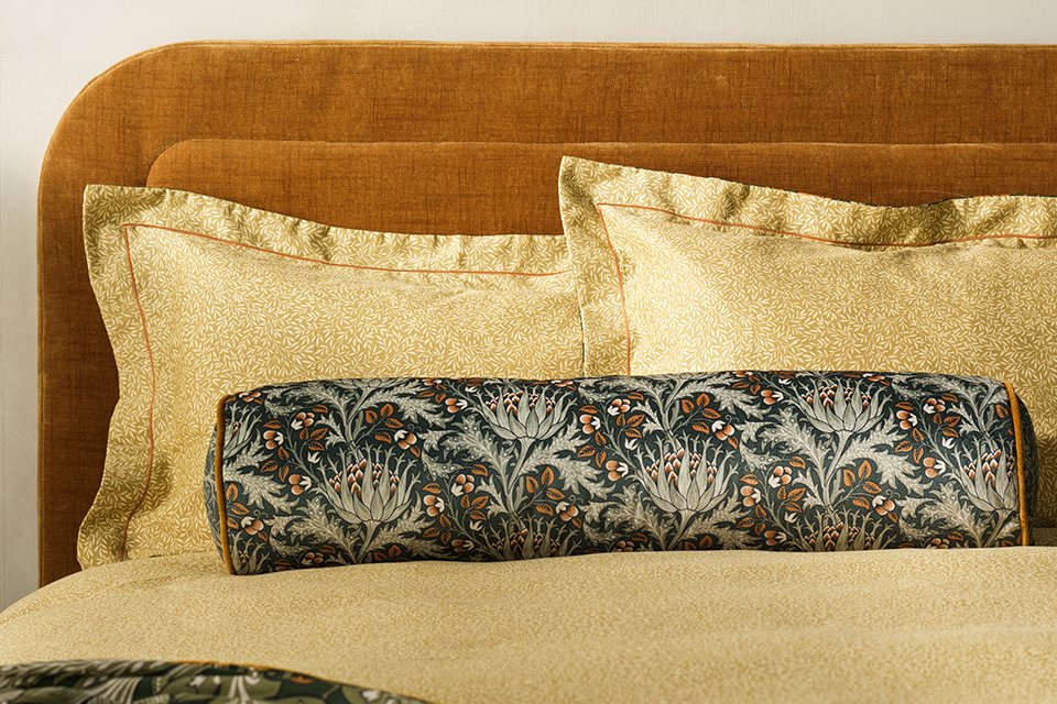 Red patterned paisley bedding with green floral throw in bold and daring colours.