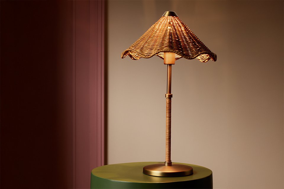 A Habitat rattan table lamp placed on a table.