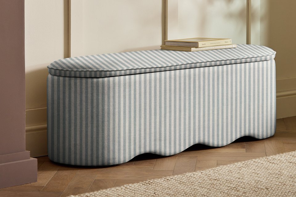 A Habitat large blue and white striped ottoman in a bedroom.